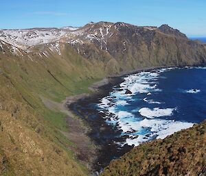 A panorama showing Kate, in the far right of picture, standing on a grassy knoll at the edge of the escarpment getting her bearings by looking across the bay with Cape Star on the far left