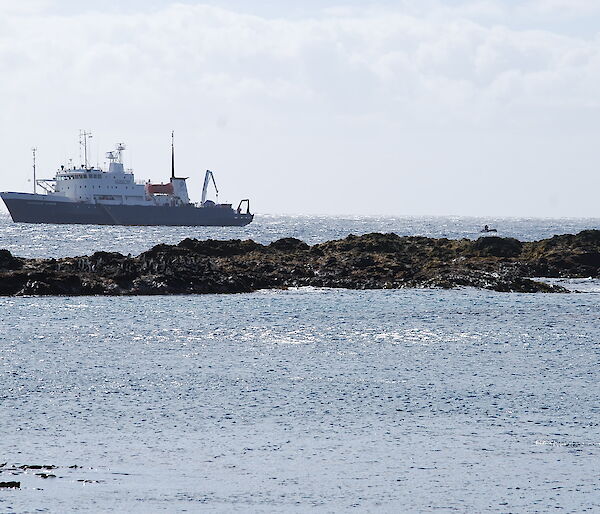 Spirit of Enderby off Sandy Bay. There is a exposed rocky outcrop in the mid-forground and one of the ships IRB’s can be seen making its way across the water