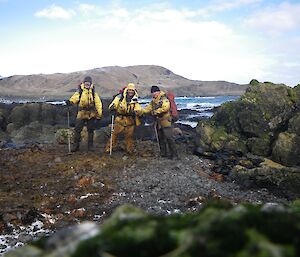 Intrepid team; Clive Barry and Chris, covered in rotting kelp after disentangling the huge pile of rope. Each is carrying a backpack loaded with pieces of rope to be brought back to Bauer Bay hut