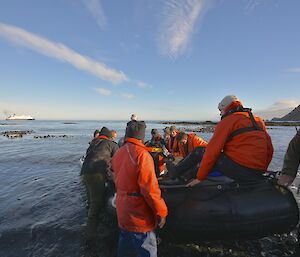 Visit by the tourist vessel Caladonia Sky. The three BAS team members Dom, Steve and Wim went back on the vessel. The image shows the black IRB in the foreground with crew and passengers just about to make their way to the ship which is visible in the distant background