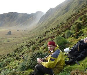 Ange and Karen sitting on a gentle slope, having lunch, just above Soucek Bay.