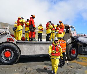 Welcome to Macquarie Island — the summer expeditioner, dressed in their yellow weather-proof gear and life jackets, are helped off the LARC