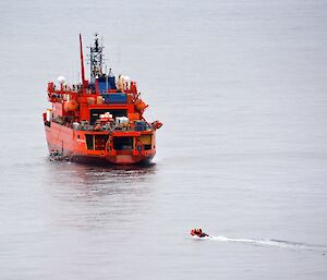 On a calm sea a LARC is along side the Aurora Australis, while one of the IRB’s approaches