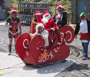 Santa Claus and Mrs Claus in red sleigh being with elves arrive at Macca