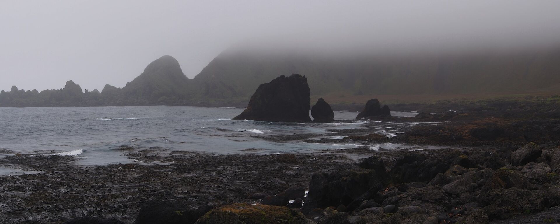 Panoramic view across Soucek Bay, with low cloud and mist seen on the escarpment in the background
