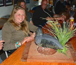 Jaimie admiring her birthday cake, in the shape of a sootie albatross on a nest — complete with sooty albatross calls coming from a speaker embedded in the tussock grass