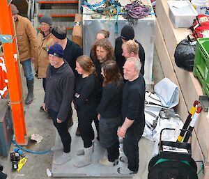 New Zealand team weigh in. All nine members, dressed in ‘all black', are standing on the large scales in the Green Store