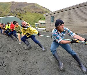 The Aussie team trying hard to win ‘The Ashes'. The nine member team are all leaning back on the rope. The foot marks in the sand suggest that they are losing ground.