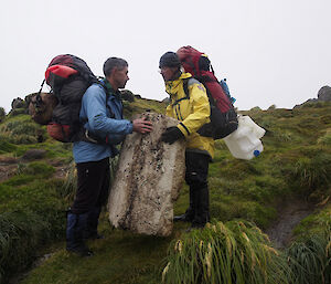 Keith and Clive contemplating the removal and carrying of a huge piece of styrofoam, measuring about a metre by 50 centimetres. Both clive and Keith have their survival pack on their back loaded with marine debris, including a couple of large plastic containers and a small gas cylinder