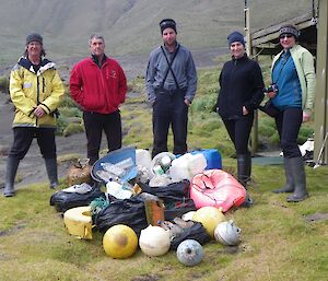 Standing on the grassy area beside Bauer Bay hut with the marine debris, Clive, Keith, Kris, Bianca and Vicki