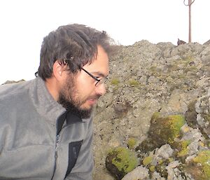 F11 — Luis Pertierra — author of this item and photographer of the images. It is a side profile of Luis looking at some moss on a rock stack near the station