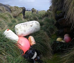 Debris stash at Unity Point, consisting of several different coloured fishing floats, black plastic bags filled with smaller pieces of rubbish and a large block of styrofoam — still to be collected