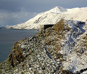 The Ham Shack in winter (in the foreground) viewed from the track up to North Head. In the distance are the snow covered slopes of the east coast escarpment