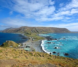 View of the isthmus and island from the top of the track to North Head on a mostly sunny day. The ocean off the east and west coast are of a different shade of blue