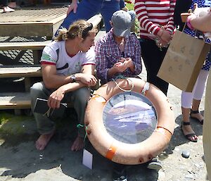 Tom and Robbie inspecting the life ring/photo frame Kris made.