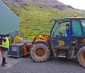Two expeditioners are shown placing the pallet at the main store with the JCB