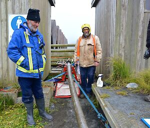 Two expeditioners inspect the refuelling hose connectio