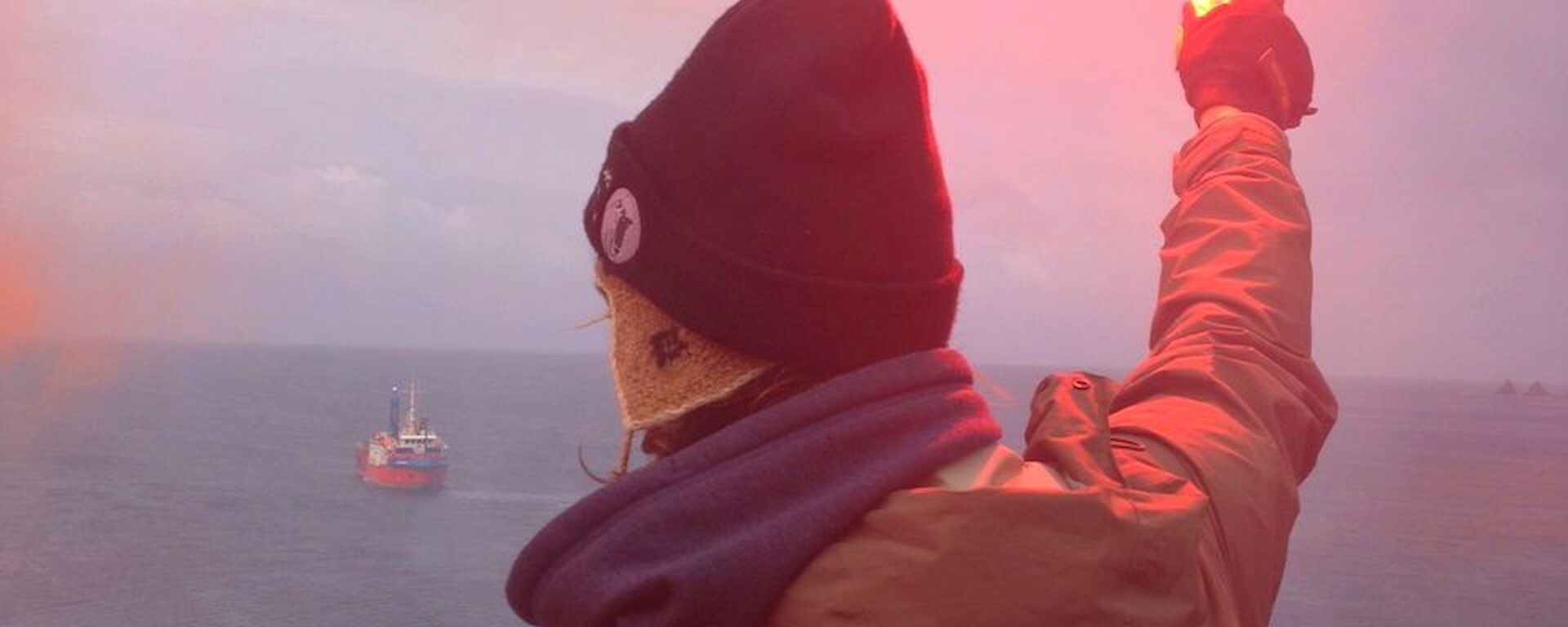 An expeditioner holds a burning flare