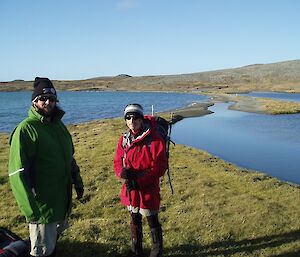 Two expeditioners in the field with lake in background