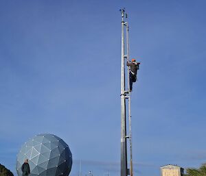 An expeditioner is seen climbing a mast tower