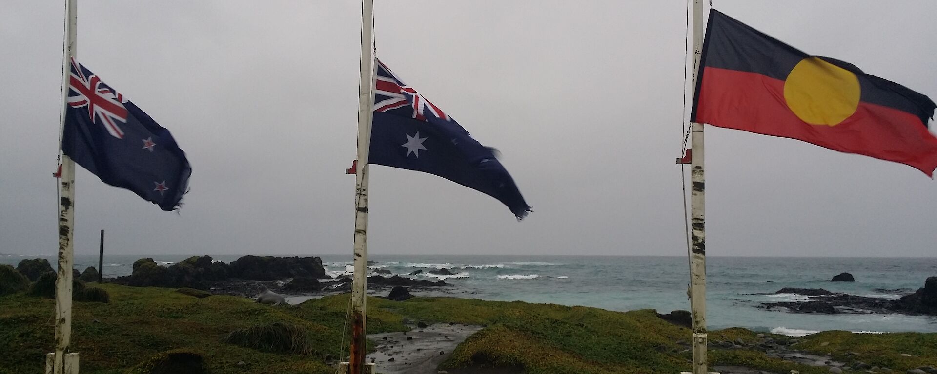 The Australian, New Zealand, and aboriginal flag are seen at half mast