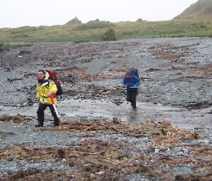 Two expeditioners crossing a creek