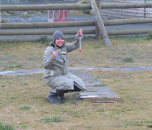 Weather observer checks a ground level thermometer