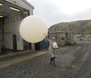 Observer exits shed with weather balloon