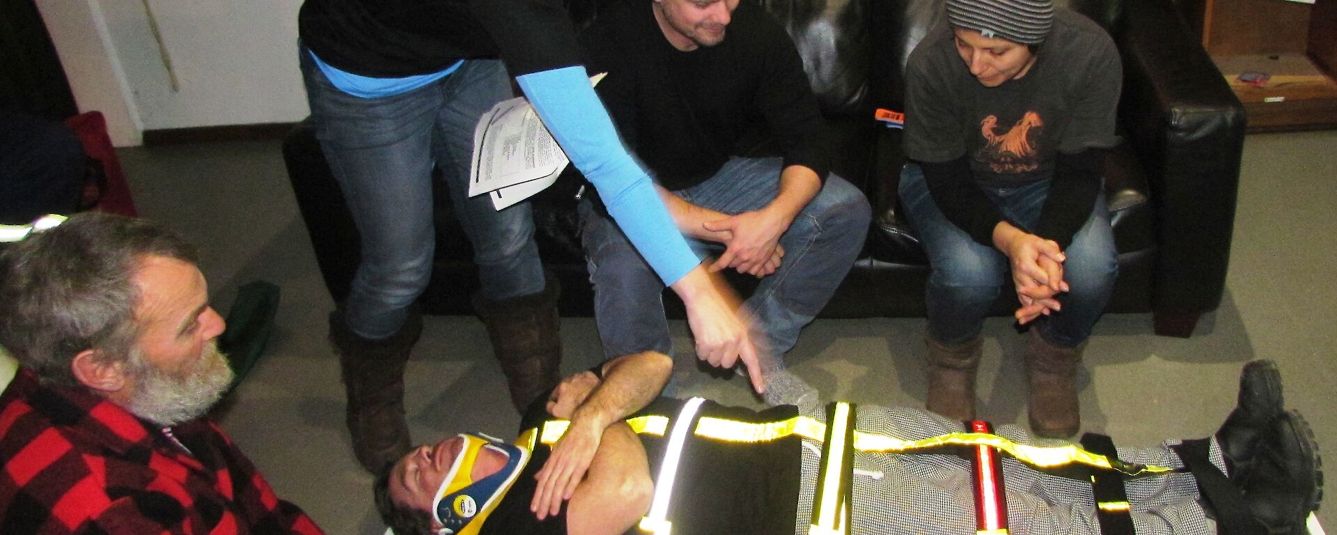 Expeditioners being shown how to put a patient on a spinal board