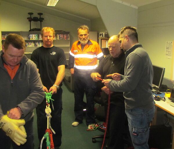 Five expeditioners setting up a rope retrieval system