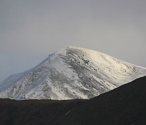 Snow covered distant hill top