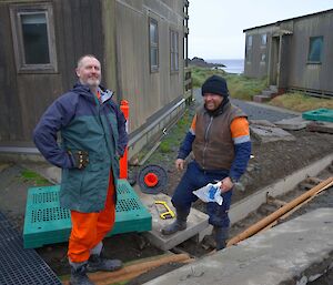Two expeditioners beside completed pipe work