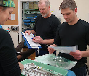 Doctor and two others prepare instruments