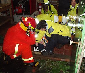Fire fighting team attending to an expedioner on a stretcher