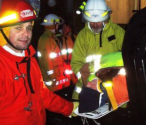 Two expeditioners in fire gear recover a ‘casualty’ on a stretcher, as part of the training exercise