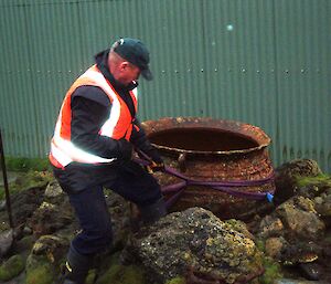 Chris applies lifting straps to a historic trypot to recoverfor conservation and display