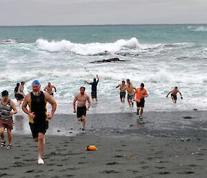 group of swimmmers run across the istmus
