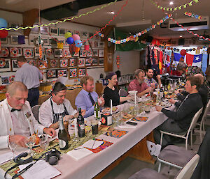 Seated for the evening meal at one long table, surrounded by colourful decorations