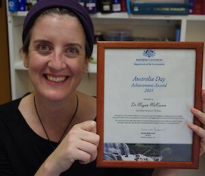 Doctor Meg holding up her Department of the Environment, Secretary’s Australia Day award and smiling