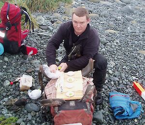 Ranger kneels to lay out the picnic lunch