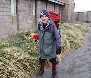 An expeditioner in hiking gear returns to station after his walk