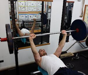An expeditioner warms up on the bench press