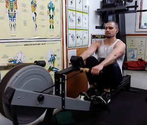 An expeditioner exercises on the rowing machine