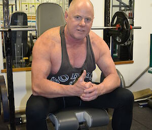 An expeditioner sits on some gym equipment