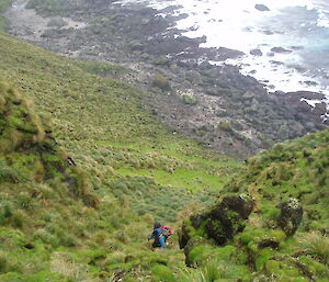 Two expeditioners climbing a steep slope