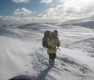 Macca expeditioner in the snow, walking up a hill