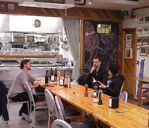 Expeditioners sit around at a long table in the mess