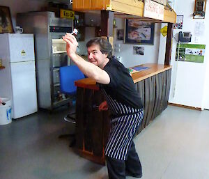 Benny the chef poses, ready to throw his dart