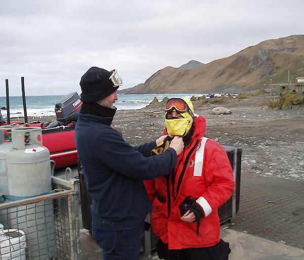 Paul helps chef Benny get dressed for cold conditions in the boats