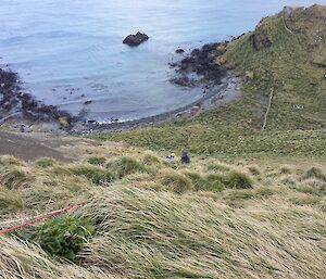 Two expeditioners disappearing down the slope, safely handling the patient